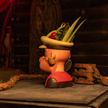 A handcrafted ceramic tiki mug featuring a sailor with a pipe and decorative toppings, perfect for tropical drinks.