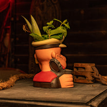 A handcrafted ceramic tiki mug styled as a sailor, featuring foliage in the hat, perfect for tropical drinks.