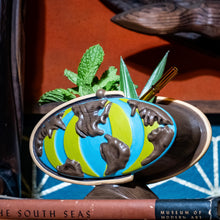 Ceramic Tiki mug designed as a globe with vibrant green and blue colors, featuring tropical garnishes