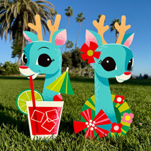 Cheerful reindeer metal yard stakes featuring tropical designs, one with a drink and the other with flowers, set of two.