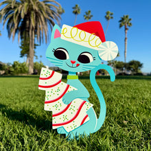 Colorful metal yard stake featuring a festive blue cat with a Santa hat and a striped treat