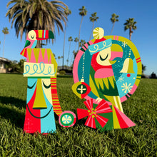 Colorful metal yard stake set featuring a parrot and moai design, perfect for festive holiday decor.