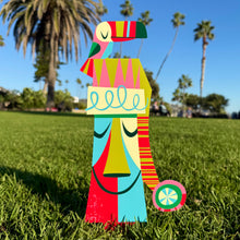 Colorful large metal yard stakes featuring a parrot and moai design, perfect for festive holiday decor.